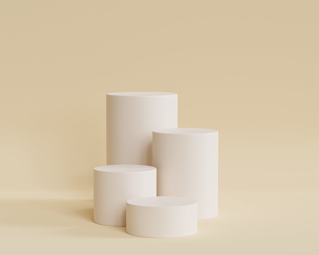 Elegant beige cylindrical podiums for a sleek and minimal design presentation.